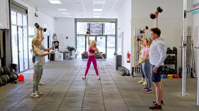 Group of people working out with dumbbells in a gym