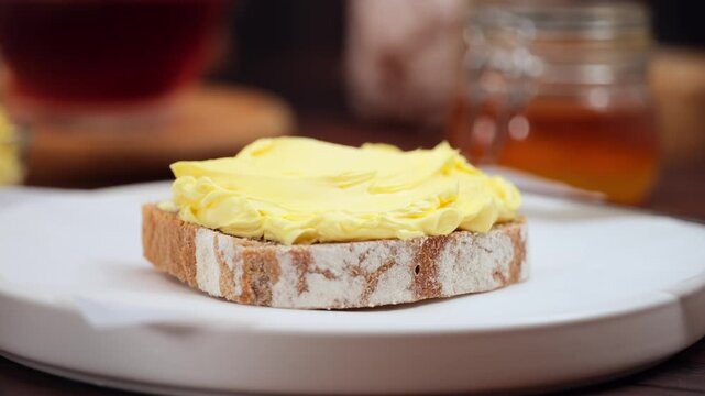 Butter spreading on fresh bread slice, close up homemade breakfast scene, copy space