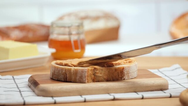 Peanut butter spread on fresh bread slice, homemade breakfast preparation, copy space