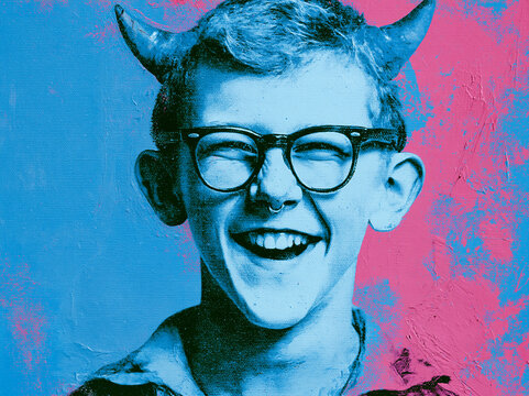 Young person with glasses and horns smiling against a colorful background in a lighthearted setting