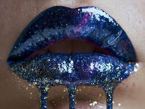 Creative lip art with glitter and galaxy theme captures attention at beauty event in an indoor setting during evening hours