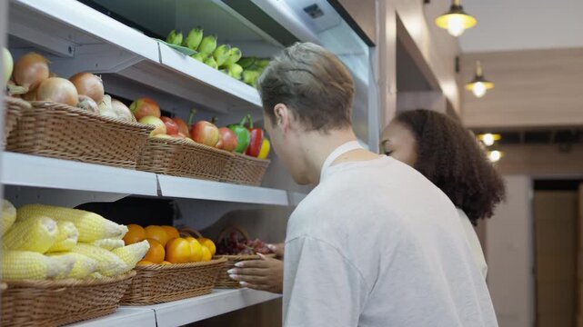 Fresh fruit display smiling man and woman grocery store retail market, supermarket fruit display shopping woman with fresh produce and grocery shelf, grocery store produce shelf with two shopper