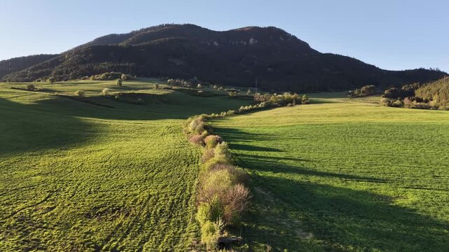 Drone flight over green fields with Predny Choc mountain in Liptov Slovakia