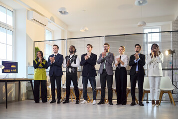 Fototapeta premium Businesspeople team give applause in office. Colleagues clapping for a successful presentation, showing support and unity in a bright office, a group of employees. Concept of support and success.