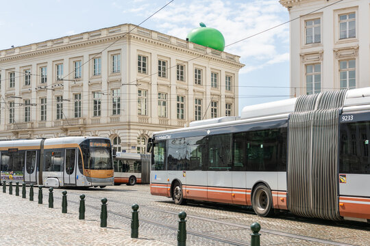 13 May 2026, Brussels, Belgium. Tram and articulated bus passing Magritte Museum with green apple rooftop in urban mobility context