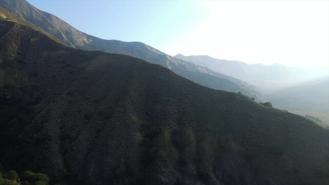 Scenic 4K wide shot of rolling green hills and misty valleys in Mount Bromo, East Java, Indonesia.
