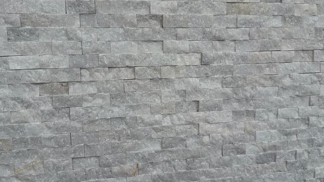 Gray stone wall background with textured surface ideal for architectural designs and construction