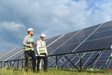 Engineers inspecting solar power plant installation outdoors © Serhii