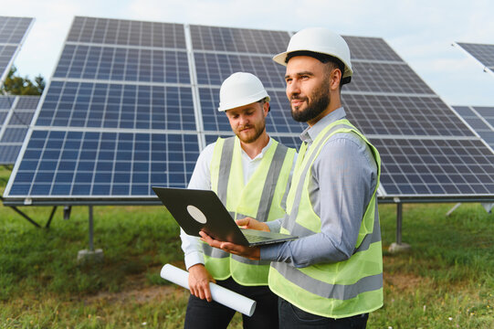 Engineers discuss renewable energy project with solar panels