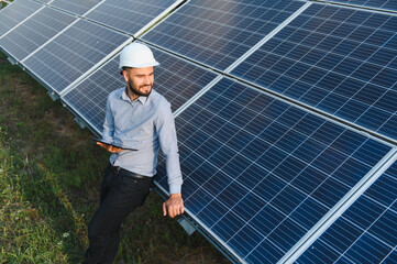 Fototapeta premium Engineer man checking solar panels using tablet