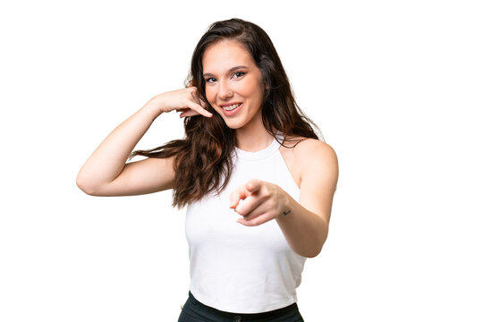 Young caucasian woman isolated over isolated background making phone gesture and pointing front