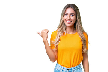 Fototapeta premium Young Uruguayan woman over isolated background pointing to the side to present a product