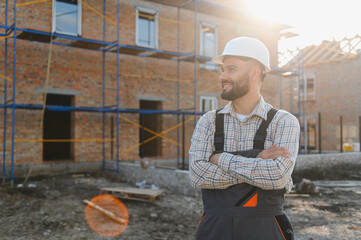 Confident construction worker standing at building site