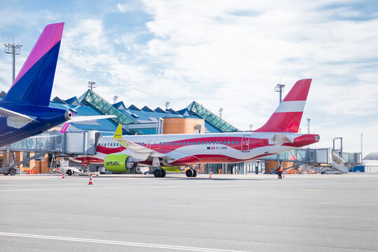 Tallinn, Estonia, May 7, 2026,  An airBaltic Airbus A220 in a special Latvian flag livery parked at the airport terminal gate next to a Wizz Air plane.