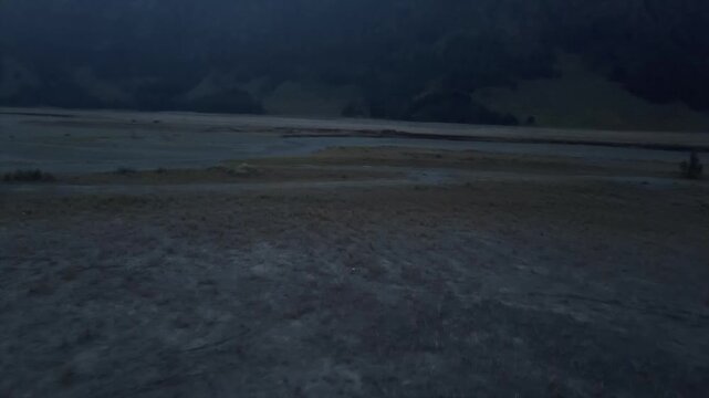 Wide 4K cinematic view of the vast volcanic sand sea at Mount Bromo caldera, East Java, Indonesia.