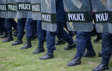 Fototapeta premium Riot police control the crowd practice and review on the grass field.