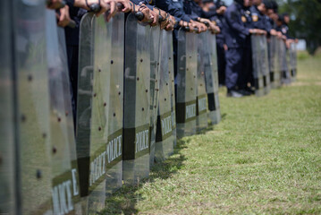 Fototapeta premium Riot police control the crowd practice and review on the grass field.