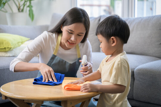 Asian mother and son doing house cleaning together at home. Family bonding through household chores, teaching responsibility, teamwork, and hygiene cleanliness in daily life.