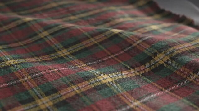 Close up view of cozy fabric with red, green, and yellow tartan plaid pattern for background use
