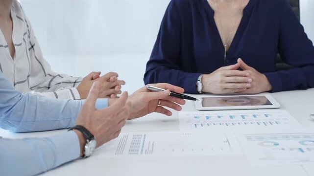 Business people analyzing financial data using charts, graphs, and digital tablet, working together to develop strategies and make informed decisions in modern office