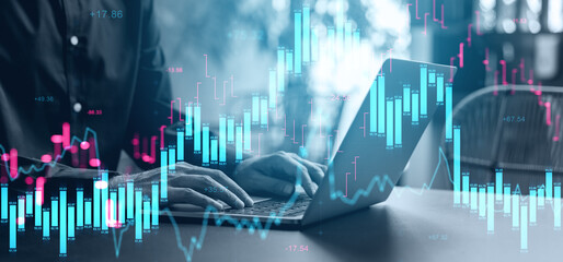 Hands typing on laptop with glowing candlestick chart overlay showing financial market activity and volatility in modern business environment.. © ImageFlow