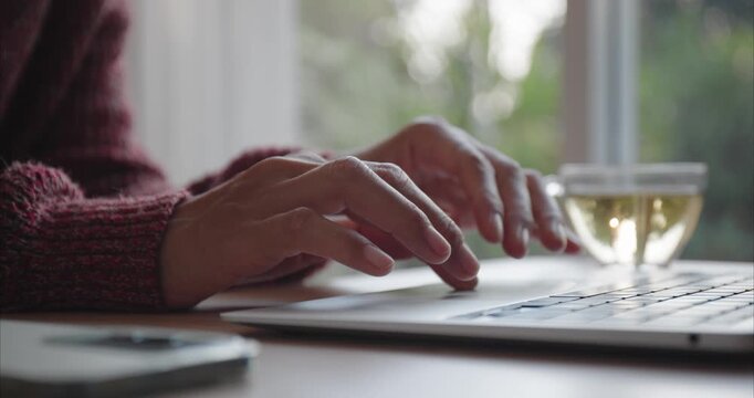 Hand of Asian woman using laptop, Asia business typing work on computer at home, Close up of women hand, Side view	