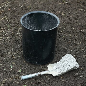 Garden bucket and shovel with wood ash as organic fertilizer. Organic and cheap way how to manure plants and flowers.