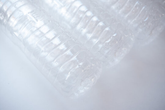 Plastic bottles lying on a white surface, representing plastic waste, recycling, and environmental impact