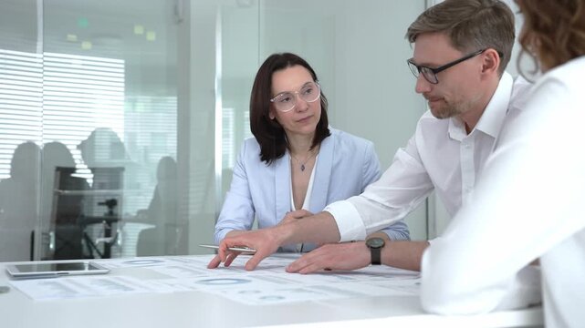 Business professionals collaborating in a modern office meeting, discussing strategies and brainstorming ideas for a project, showing effective teamwork and communication