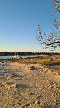 Le c&eacute;l&egrave;bre phare du Cap Ferret vu depuis l'autre c&ocirc;t&eacute; de la conche du Mimbeau sur la Fl&egrave;che de sable avec son beau paysage dunaire &agrave; l'heure du coucher du soleil (Bassin d'Arcachon, Aquitaine)