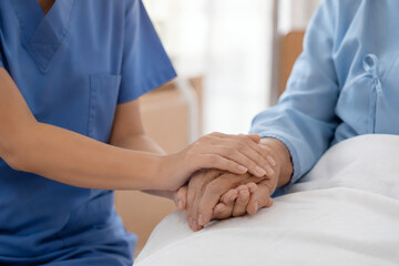 Obraz premium Compassionate Nurse Holding Senior Patient Hands in Hospital