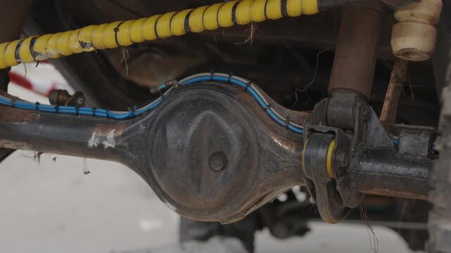 Cinematic close-up of a rugged off-road vehicle rear differential axle