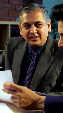 Indian investors discussing stock market profit in modern office setting, Asian young corporate executives or financial analysts analyzing investment charts and returns in office