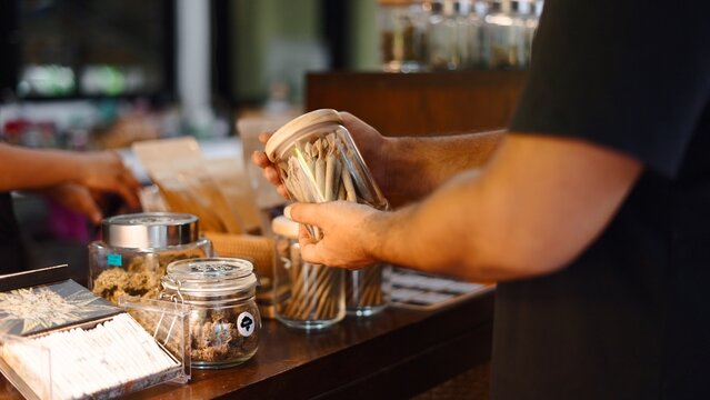 Customer hands selecting pre rolled cannabis joints in a modern dispensary shop