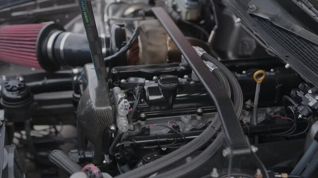  Cinematic detailed shot of modified engine bay with carbon fiber.