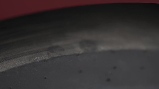 Cinematic macro shot of racing slick tire surface with heat texture