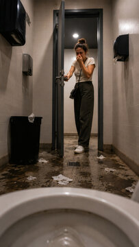 Woman Pinches Nose in Disgust as She Enters Messy Public Toilet