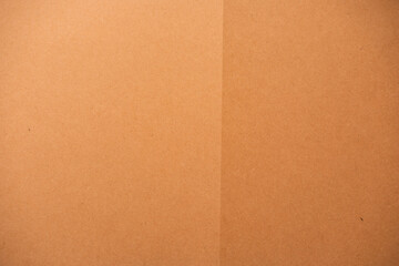 Fototapeta premium Brown cardboard texture creating a patterned background with a subtle vertical fold line, blank surface ideal for copy space