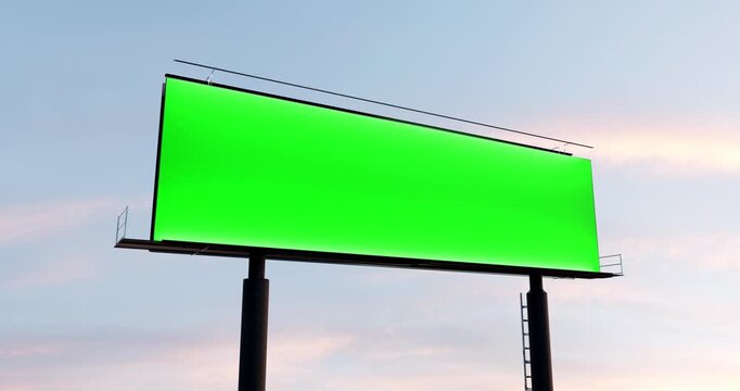 Blank green screen billboard mockup against a calm sunset sky