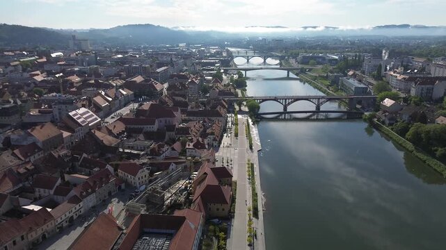 Aerial panoramic view of Maribor cityscape and bridges over Drava river at sunrise