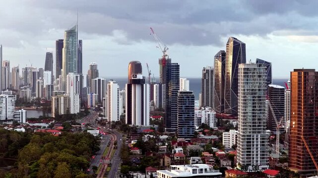 Gold Coast highway urban high-rise towers on Pacific waterfront from riverside aerial view.
