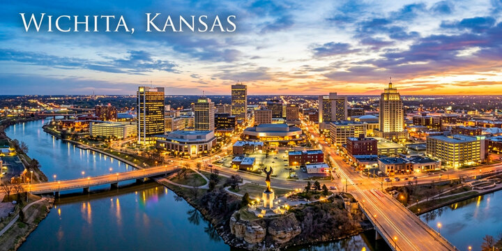 A beautiful sunset view over the city skyline of Wichita, Kansas, with a calm river and lit bridges reflecting the warm evening glow