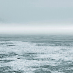 Fototapeta premium Mystical Ocean Seascape: Stormy Waves & Foggy Coastline in Moody Atmosphere