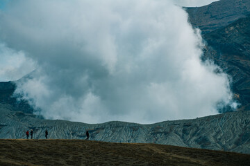Erupting crater with thick white smoke and tiny human silhouettes © 祐誼 任