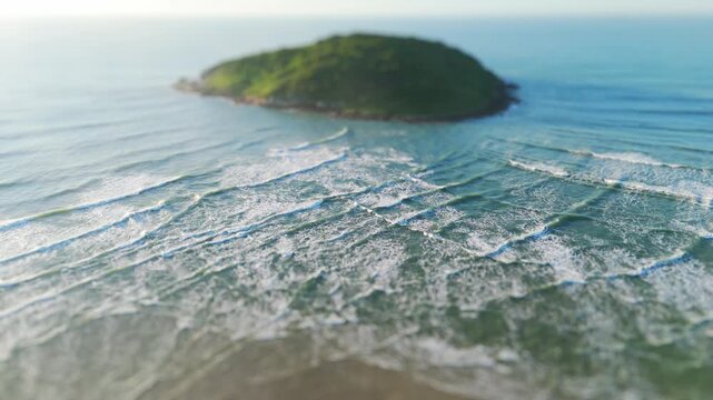 Aerial view of the island in the sea with waves interfere next to it