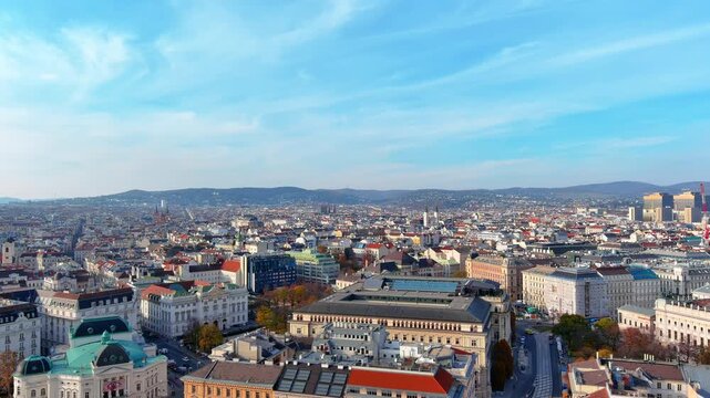 4K aerial reveal shot pulling back from the Naturhistorisches Museum dome with Helios statue across Vienna's imperial rooftops to the Vienna Woods horizon under autumn sky.