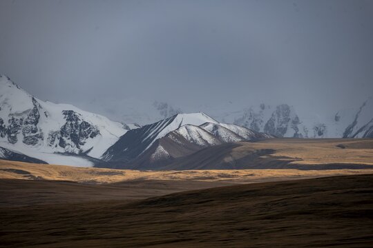 Glaciated and snow-capped mountains, dramatic landscape, high plateau, autumnal mountain landscape with yellow grass, Tian Shan, Sky Mountains, Sary Jaz Valley, Kyrgyzstan