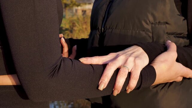 Close up of two women holding hands and arms to support each other during Sadhu board practice. Concept of friendship, trust, mutual help and spiritual partnership. Natural sunset light