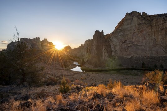 Sun star on rock walls, sunset, river course of the Crooked River, canyon with rock formations, The Red Wall, Smith Rock State Park, Oregon, USA