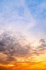 Fototapeta premium Sky sunset,Beautiful sunrise sky with vibrant gradient orange and gold colors and soft blue, Clear atmosphere with wispy clouds. Peaceful, perfect for background and copy space, vertical